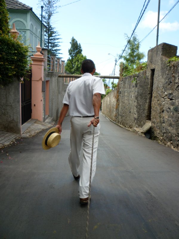 Men pull and guide sledges downhill